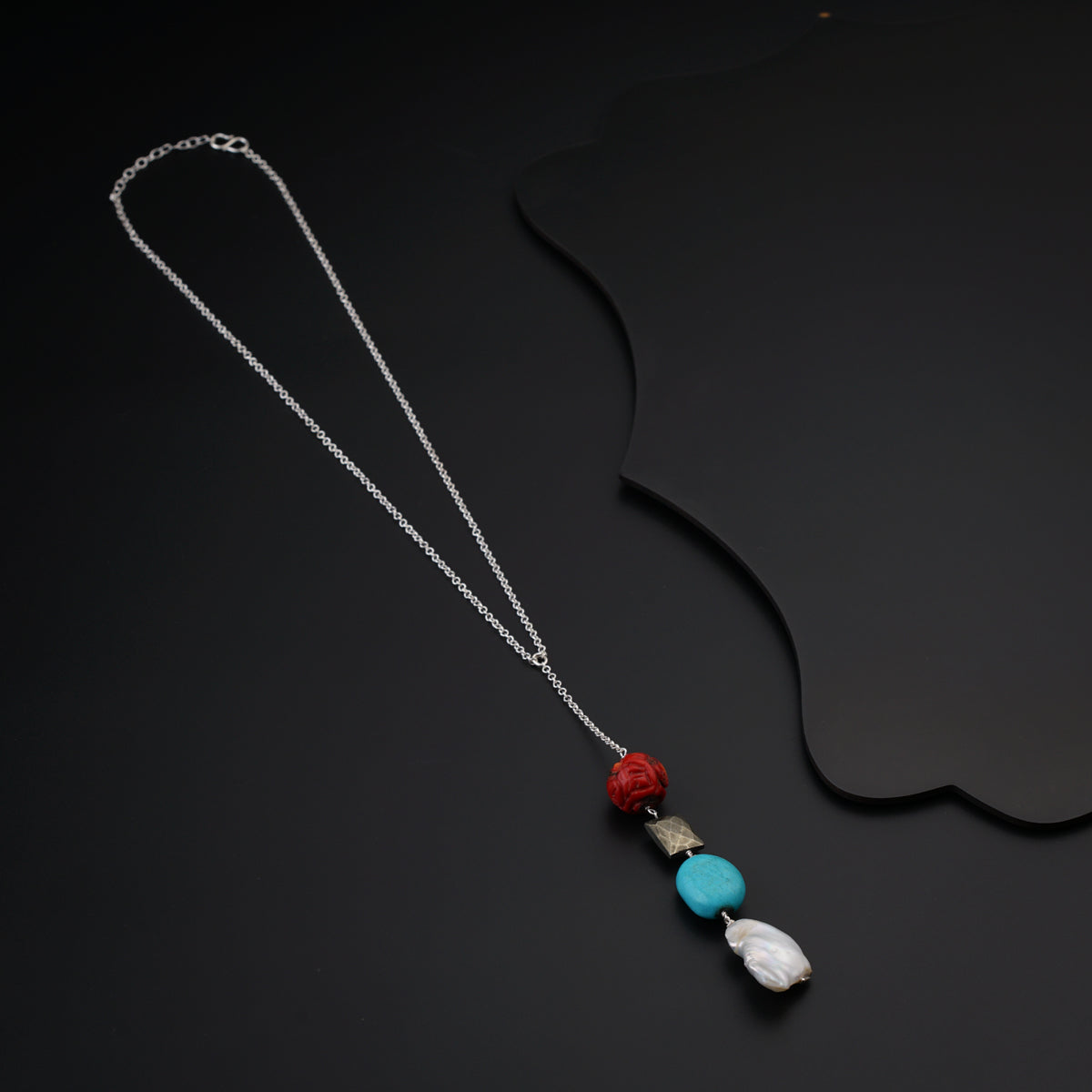 a necklace with a red, white and blue bead hanging from it