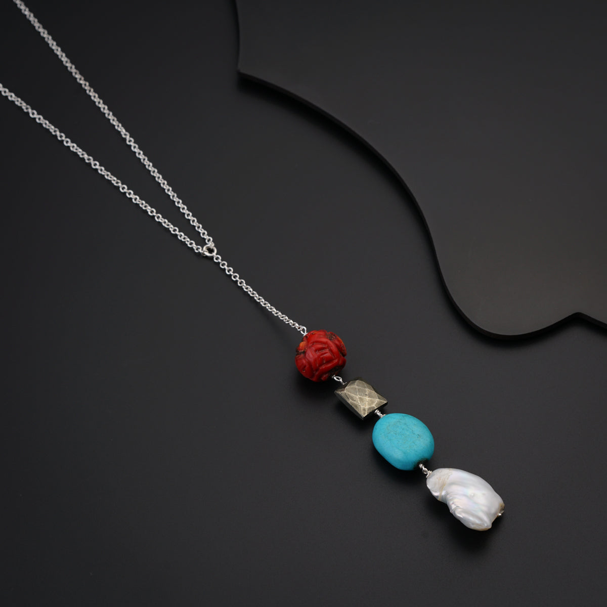 a necklace with a flower and two stones on it