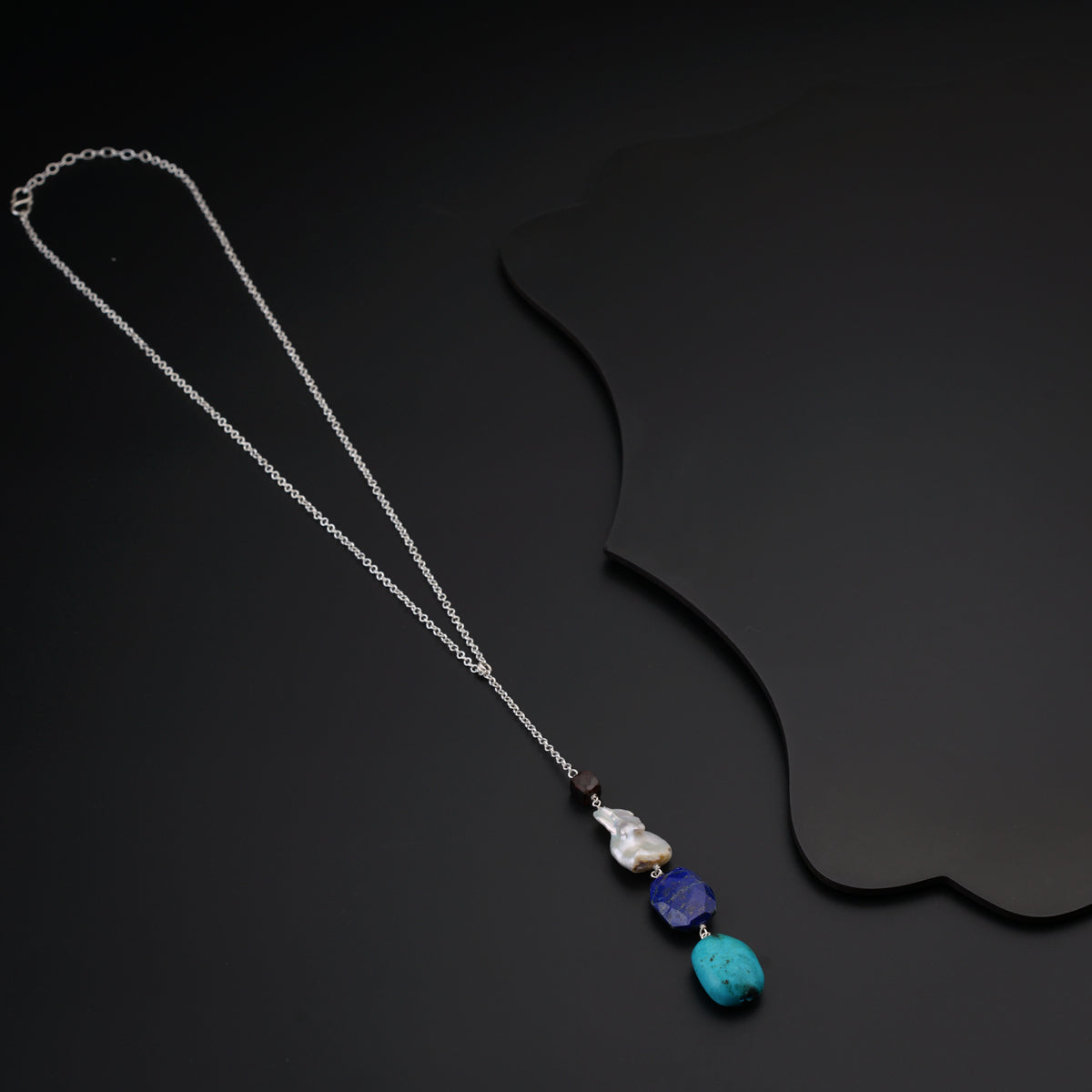 a necklace with a blue stone and a silver chain