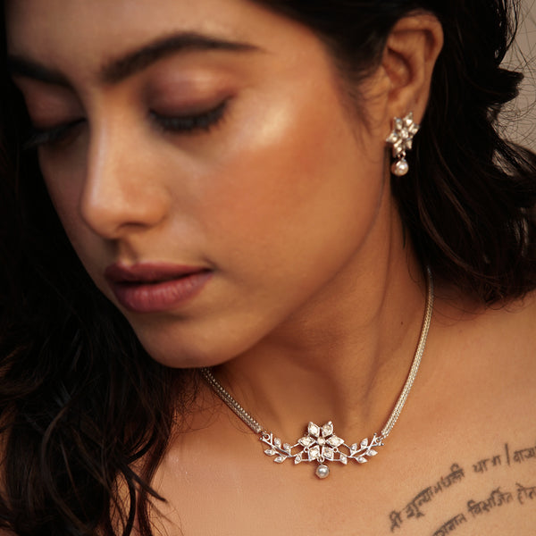 Woman wearing silver jewelry set with earrings and necklace