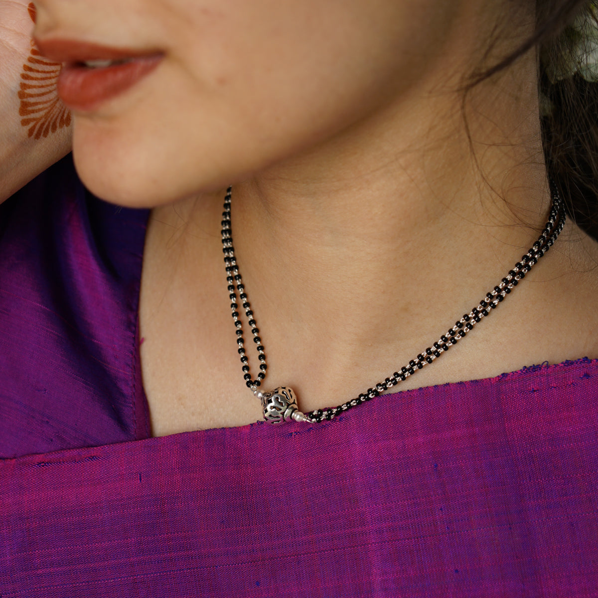 a woman wearing a necklace with a cross on it