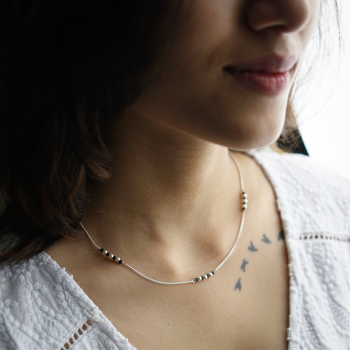 a close up of a person wearing a necklace