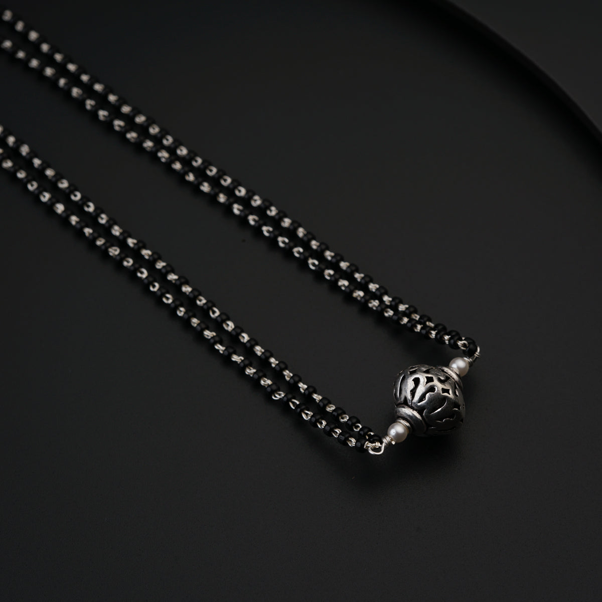 a black and silver necklace with a skull on it