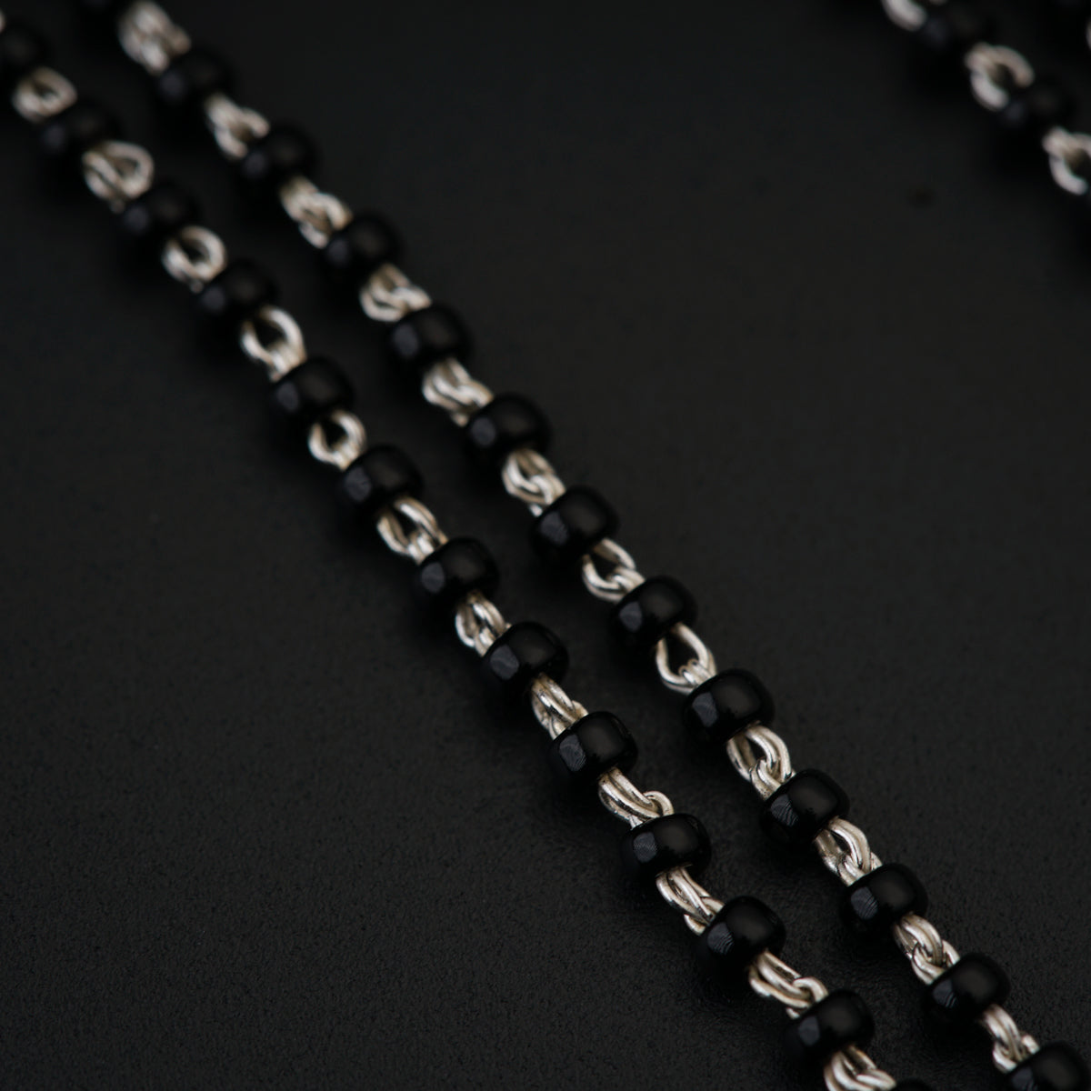 a close up of a black and silver necklace