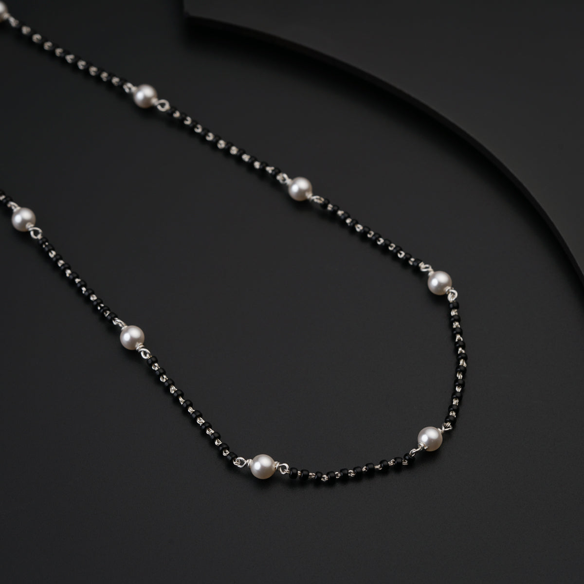 a black and white necklace with pearls on it