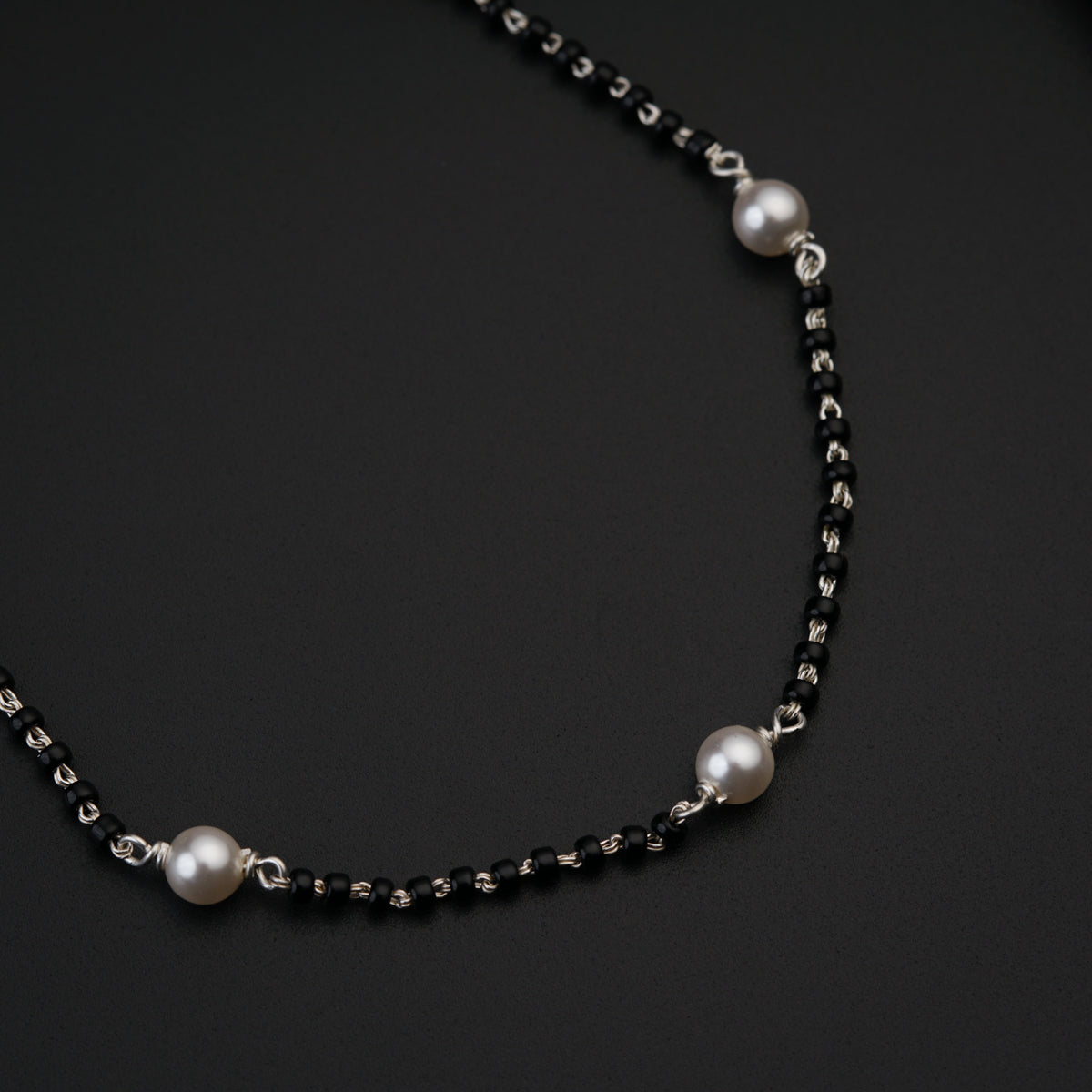 a black and white necklace with pearls on it