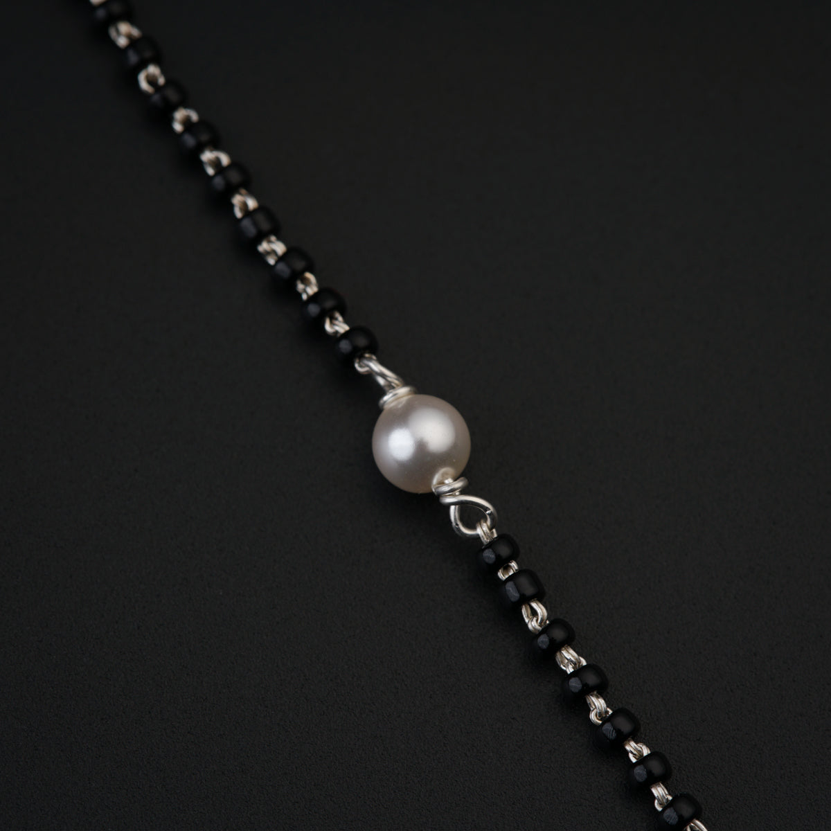 a black and white necklace with a pearl on it