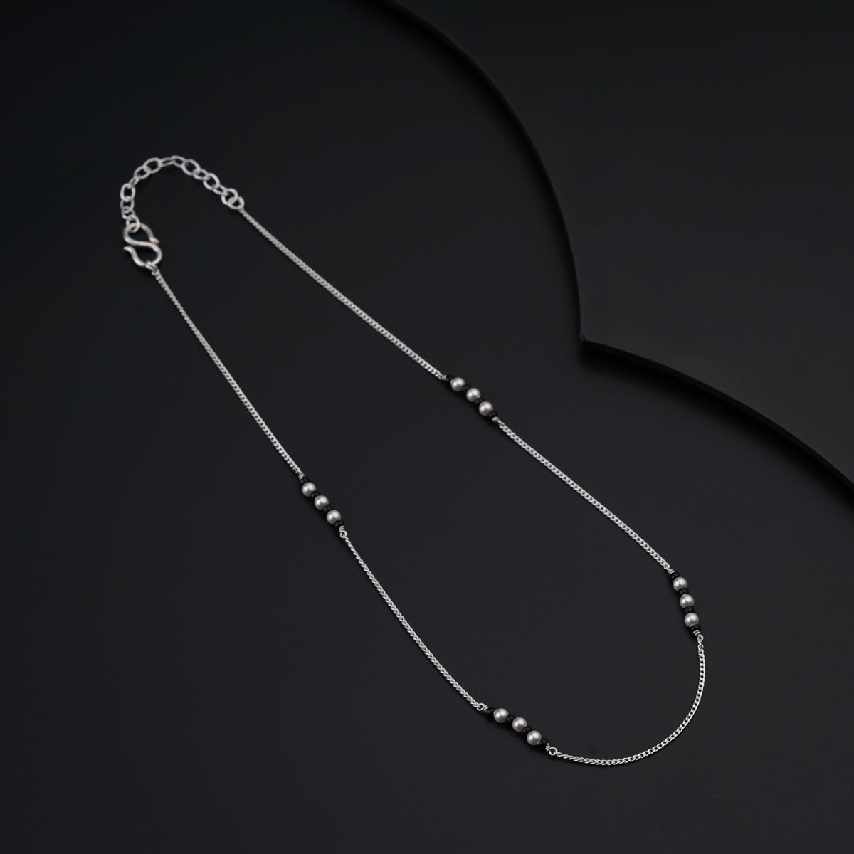 a long necklace with beads on a black background