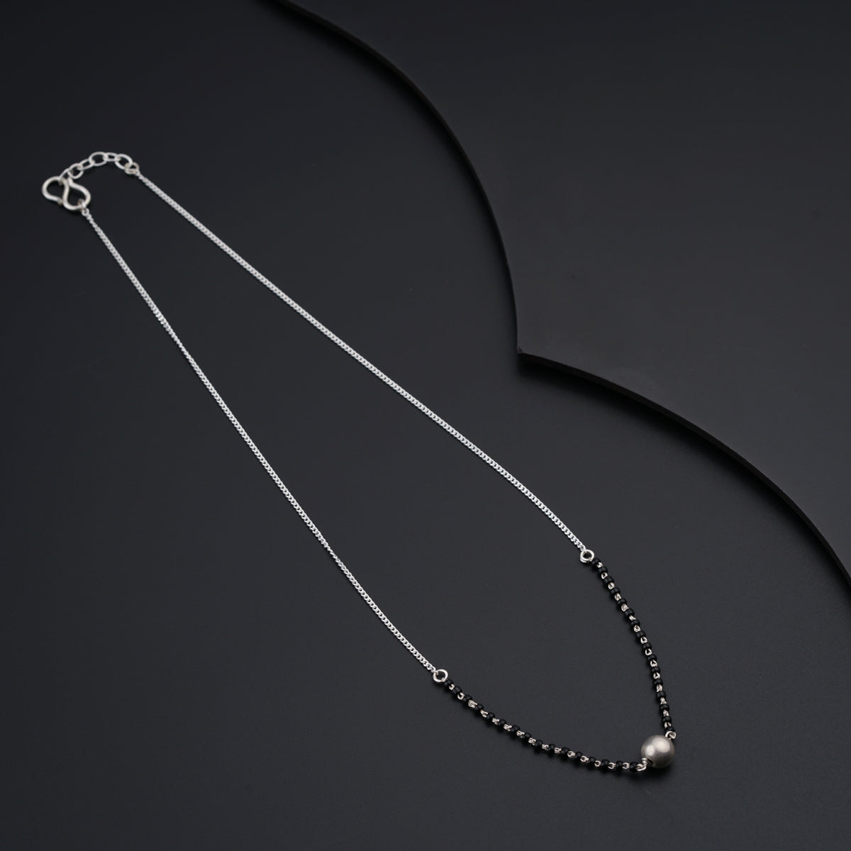 a black beaded necklace on a black background
