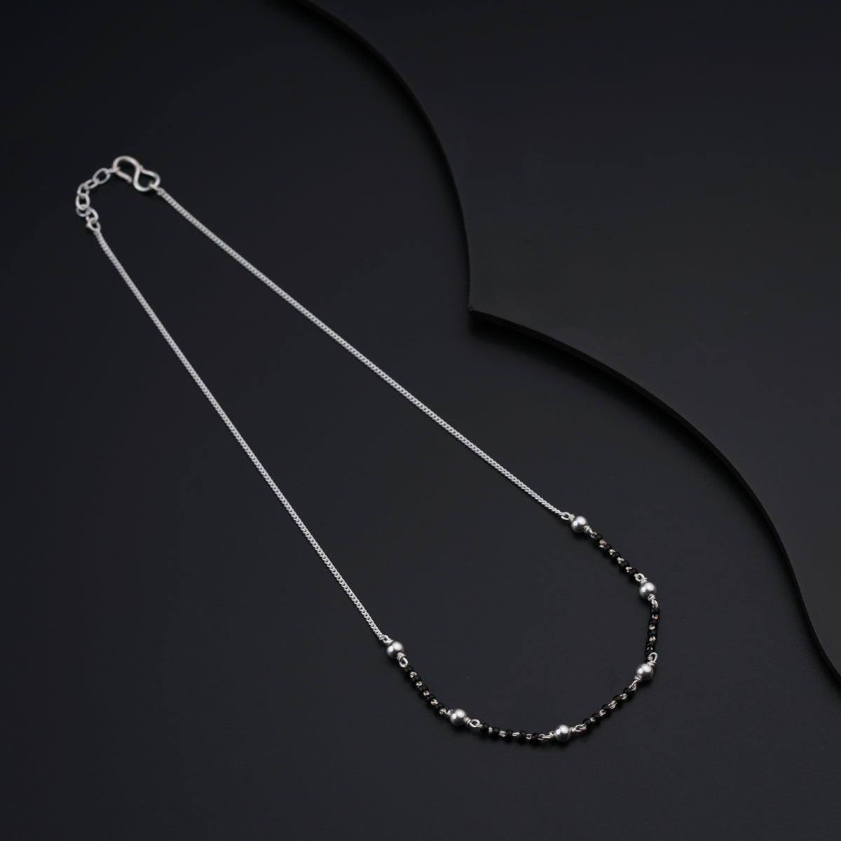 a black and white necklace on a black background