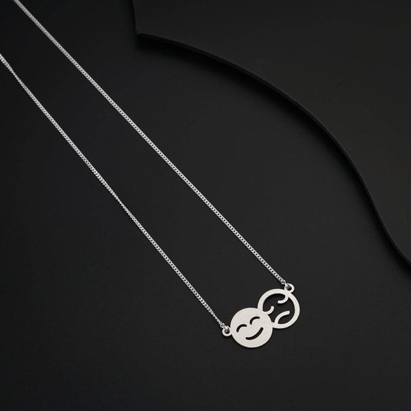 Elegant silver necklace with mood emoji charms on black background
