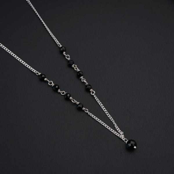 a couple of black beads on a silver chain