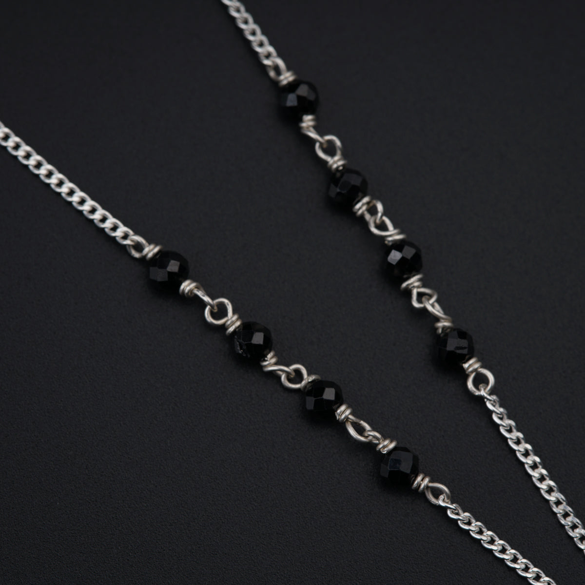 a close up of a black and silver necklace
