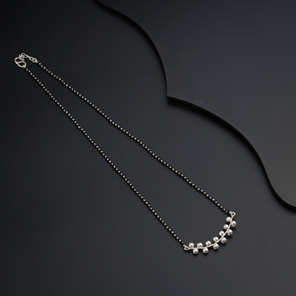 a black necklace with a silver ball chain
