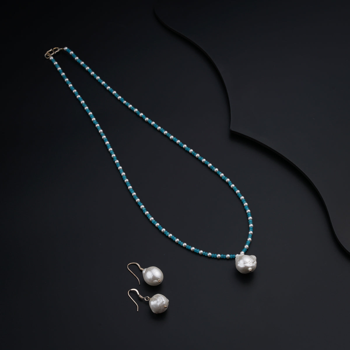 a necklace with pearls and a pair of earrings