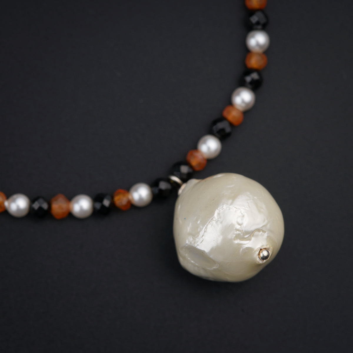 a beaded necklace with a white skull pendant