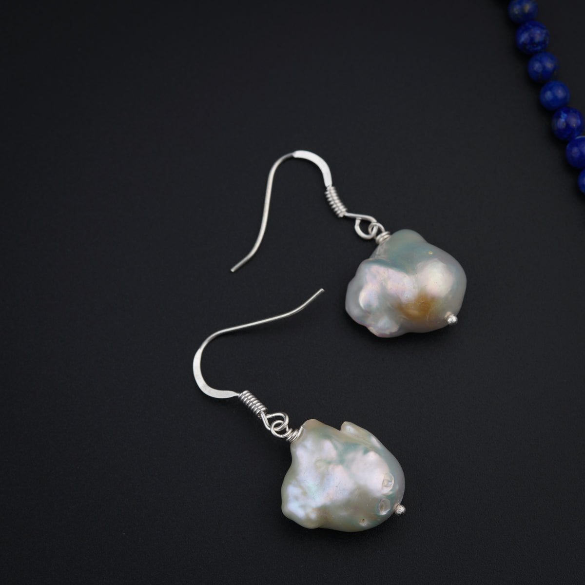 a pair of earrings on a black surface
