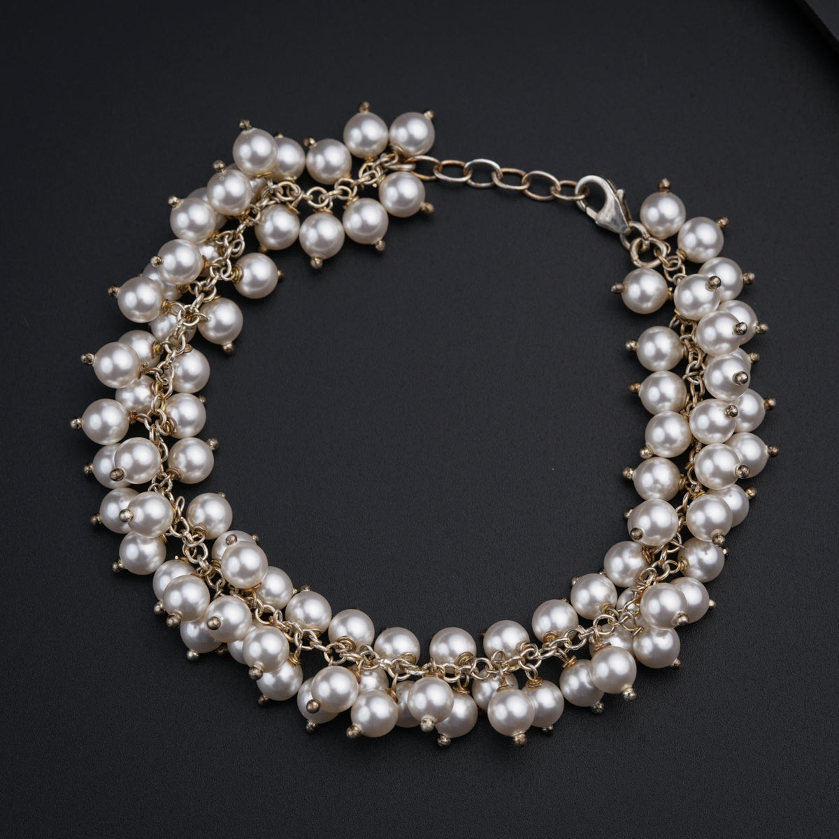 a close up of a bracelet with pearls