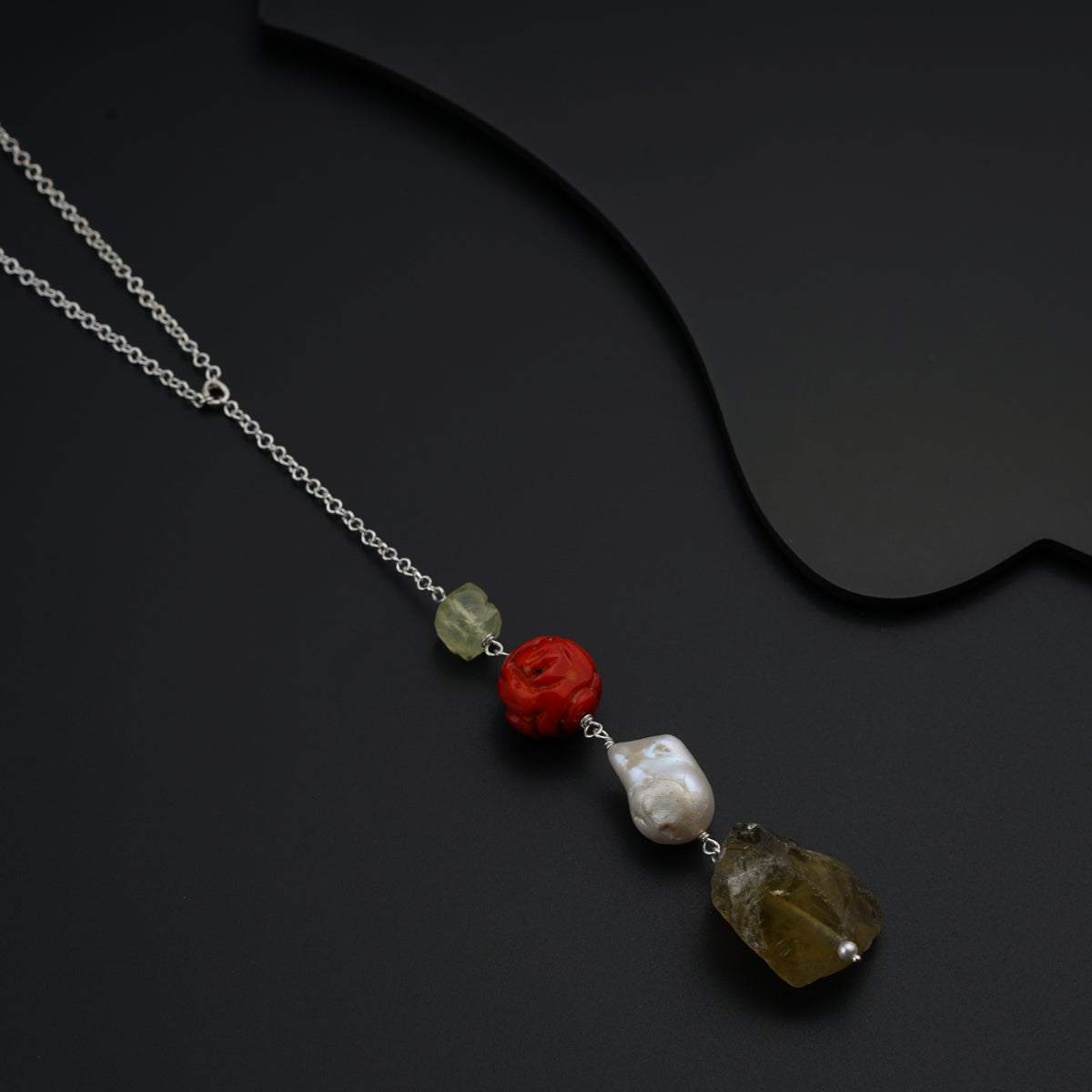 a necklace with three different colored stones on it