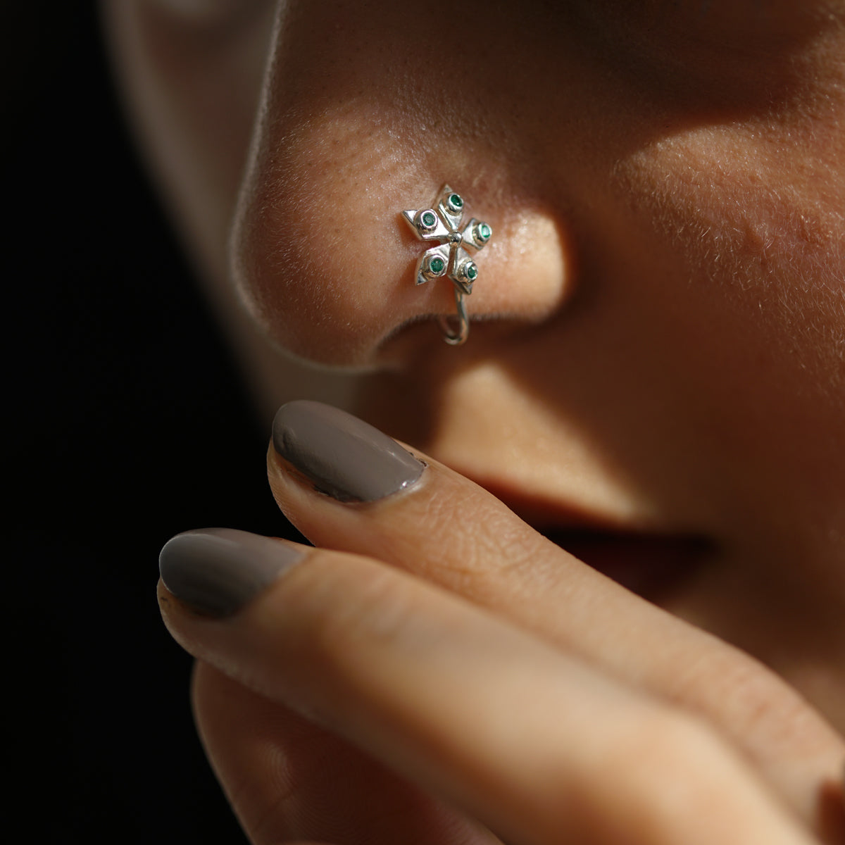 a close up of a person with a nose piercing