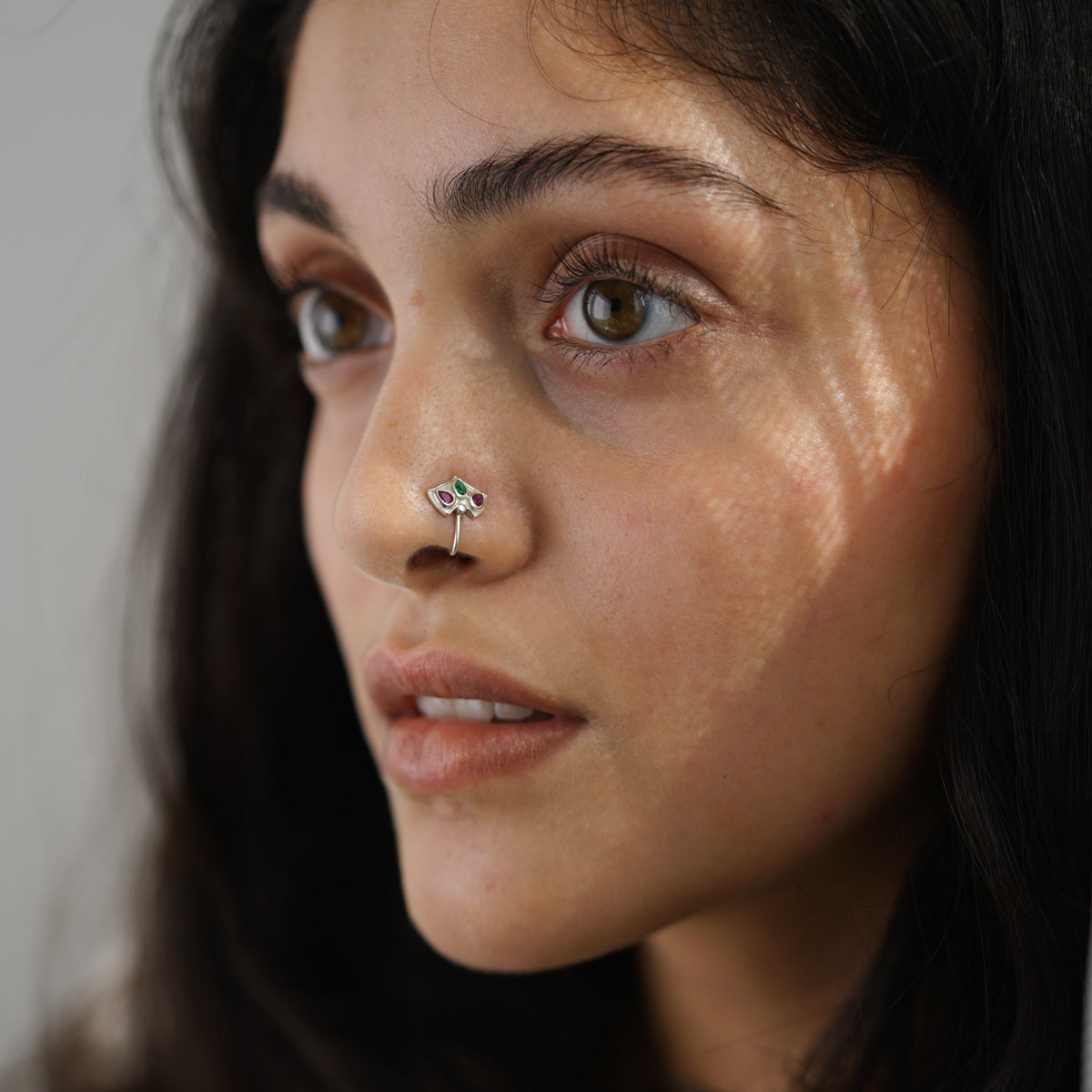 a close up of a woman with a nose piercing