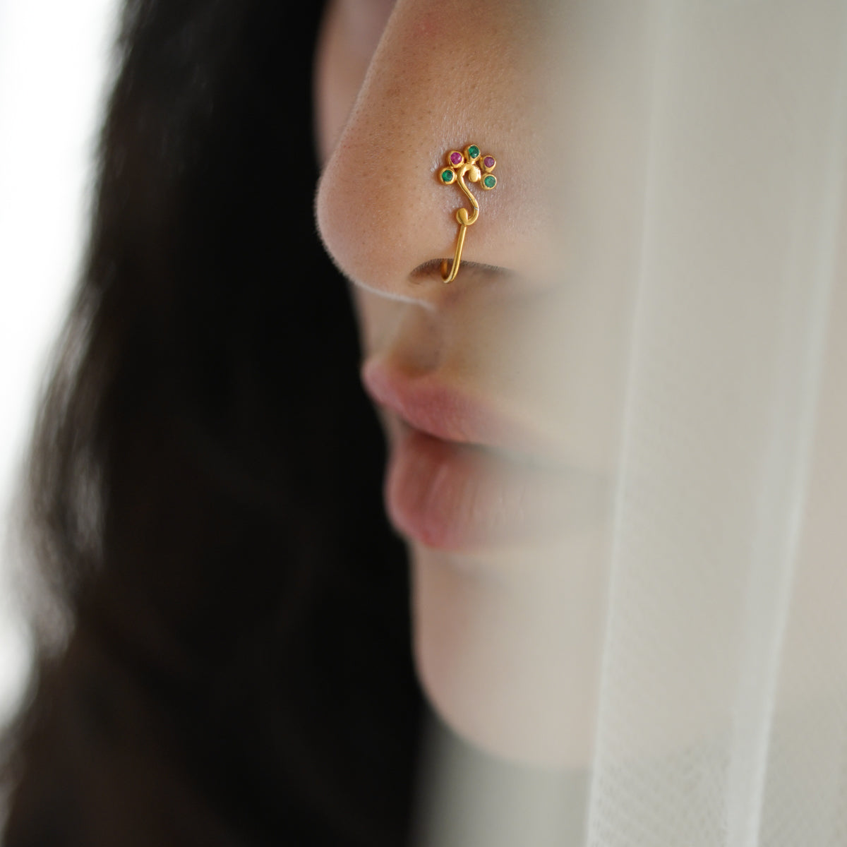 a close up of a woman's nose with a ring on it