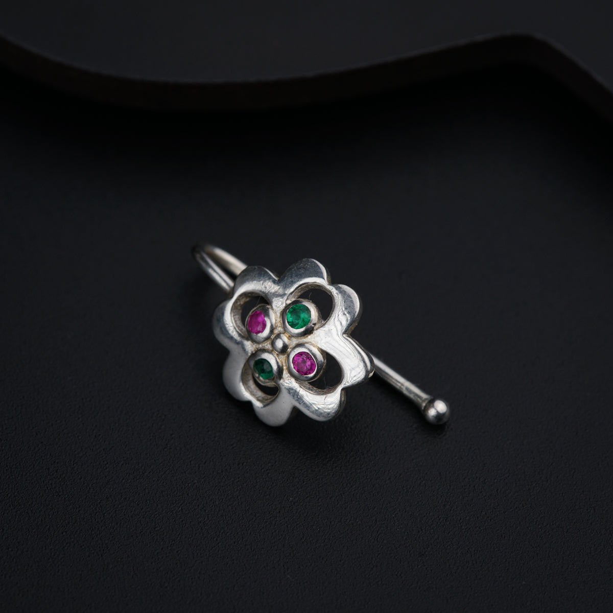 a close up of a brooch on a black surface