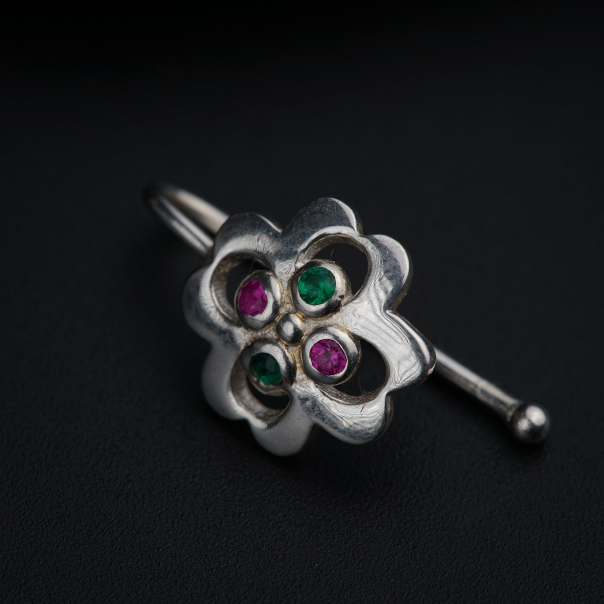 a close up of a flower shaped object on a black surface