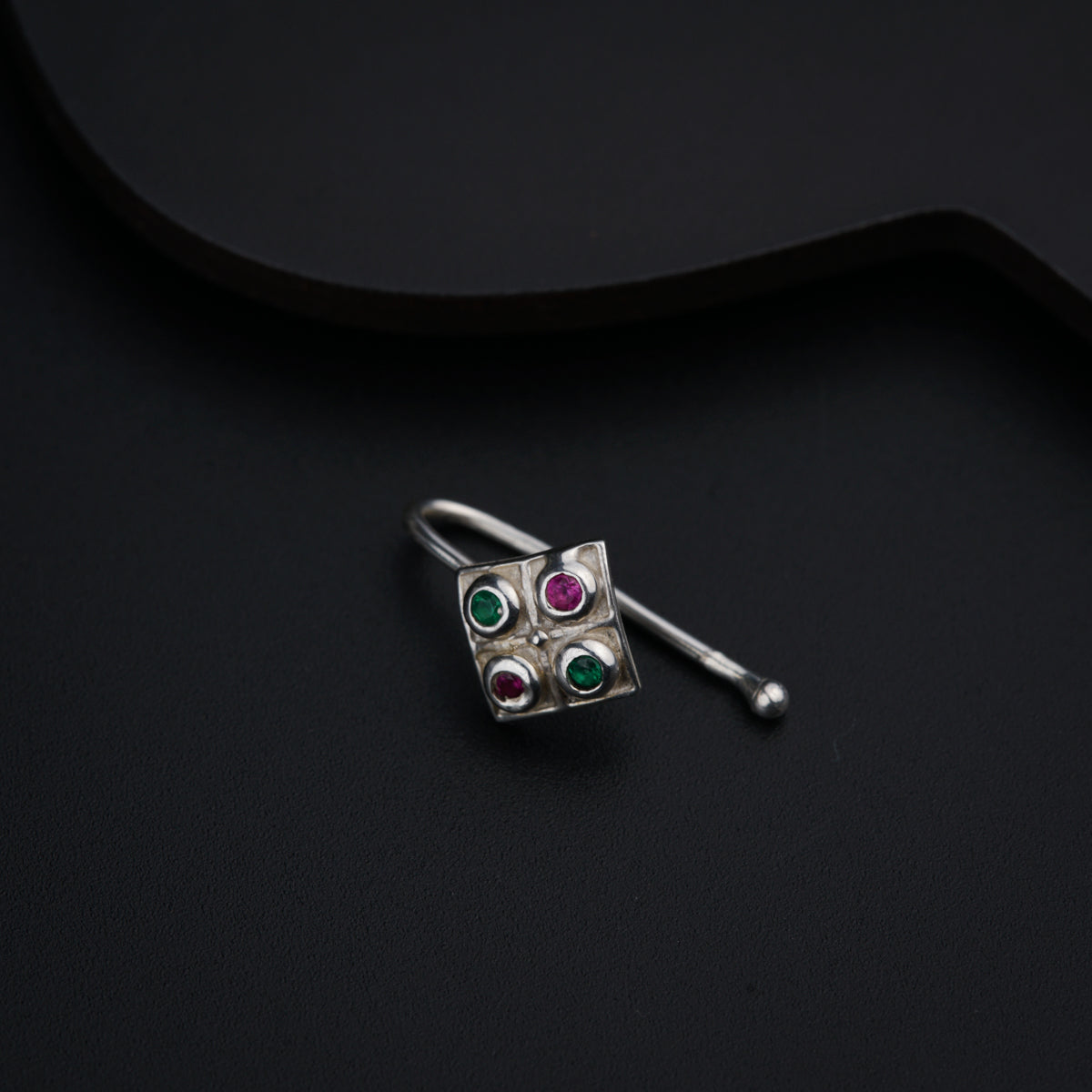 a close up of a pair of earrings on a black surface