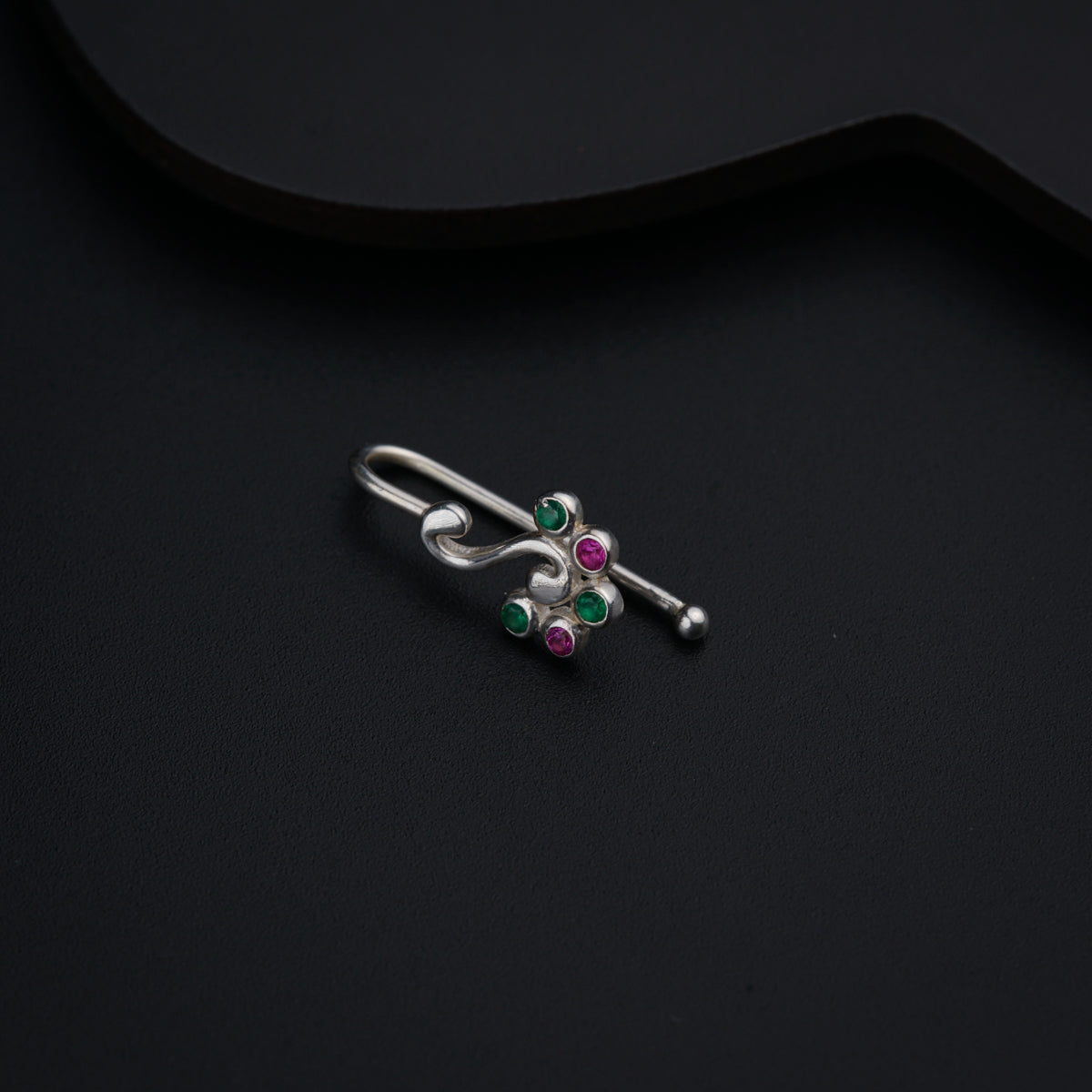 a pair of silver earrings with green and pink stones