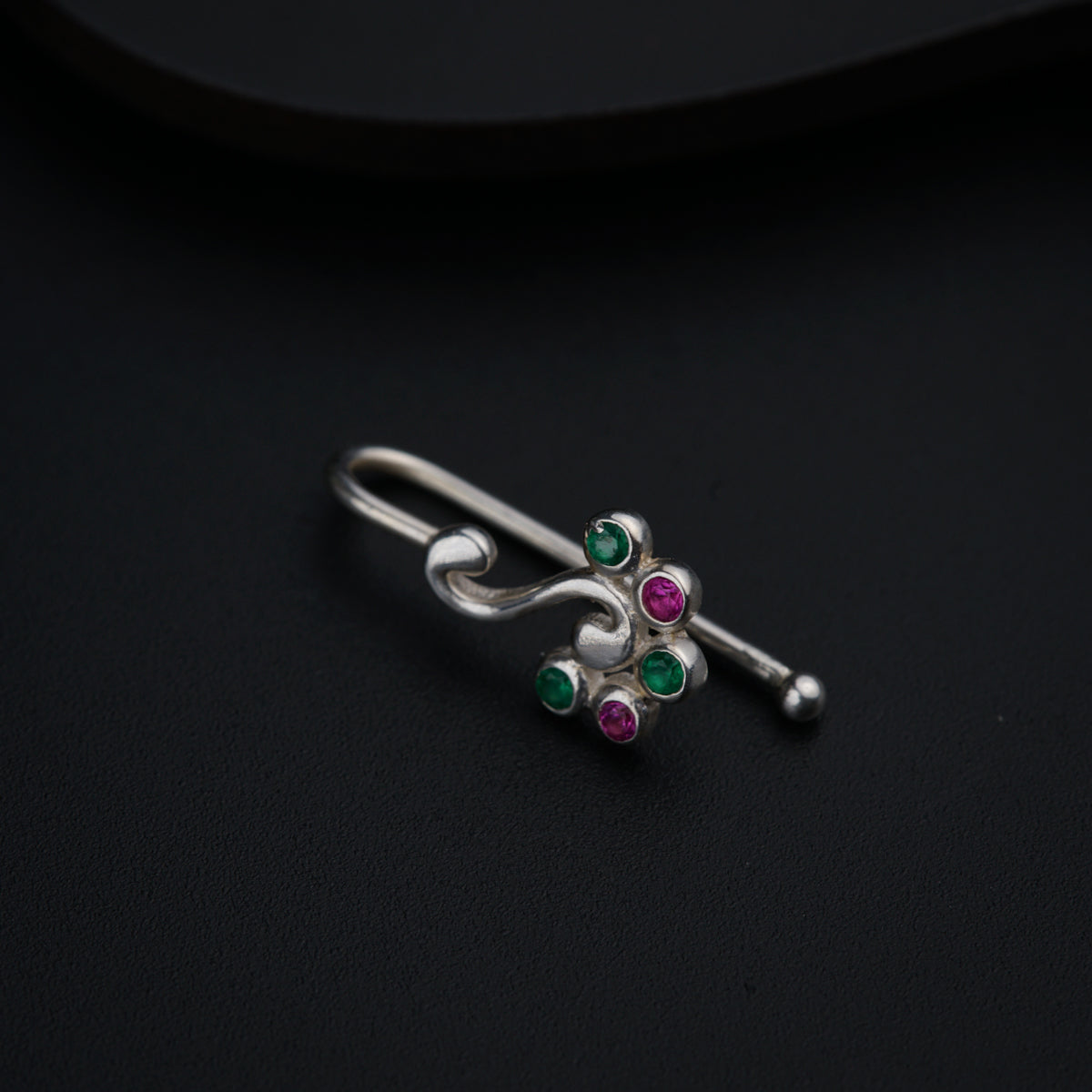 a close up of a pair of earrings on a black surface