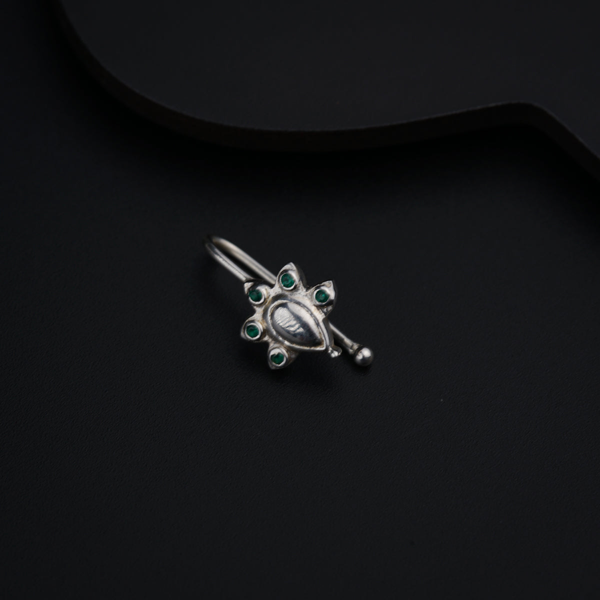 a close up of a brooch on a black surface