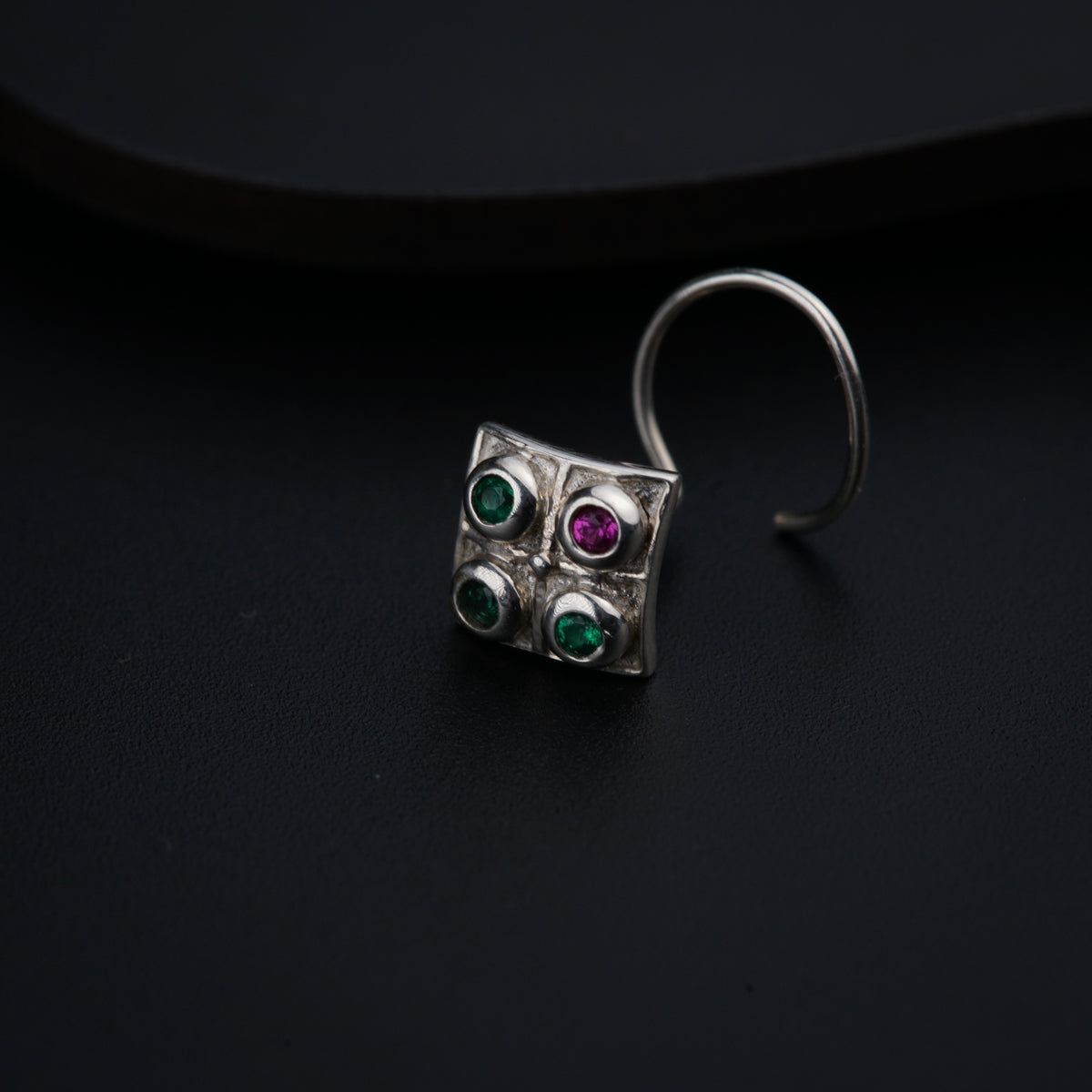 a close up of a pair of earrings on a black surface