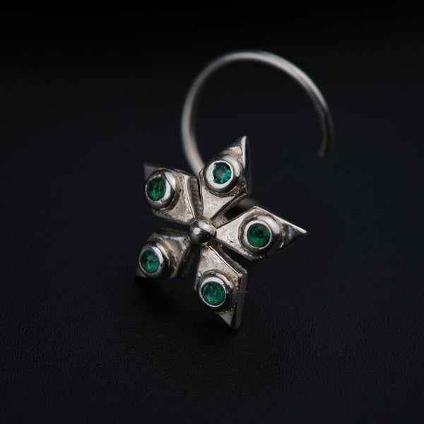 a close up of a silver ring with green stones