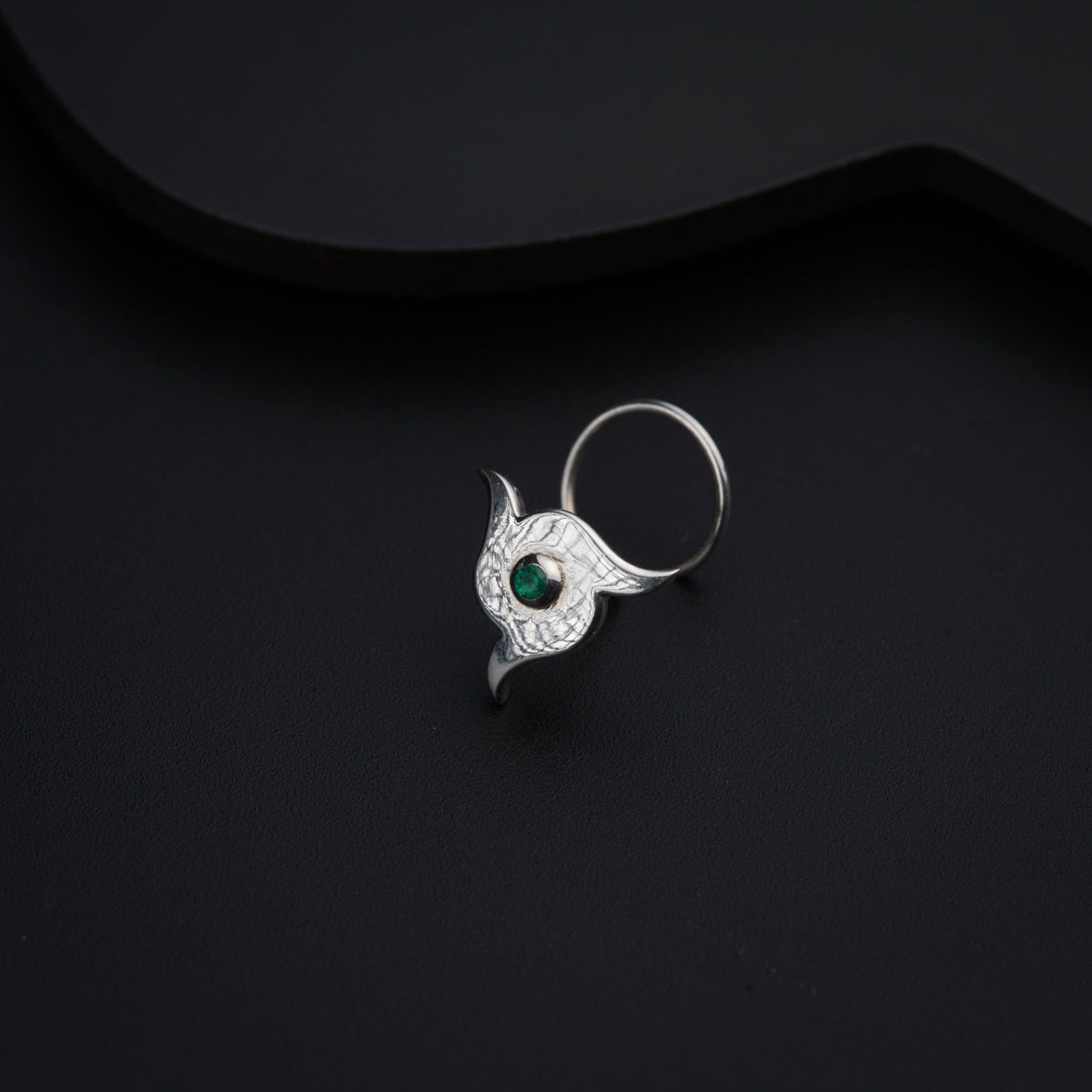 a silver ring with a green stone in the middle