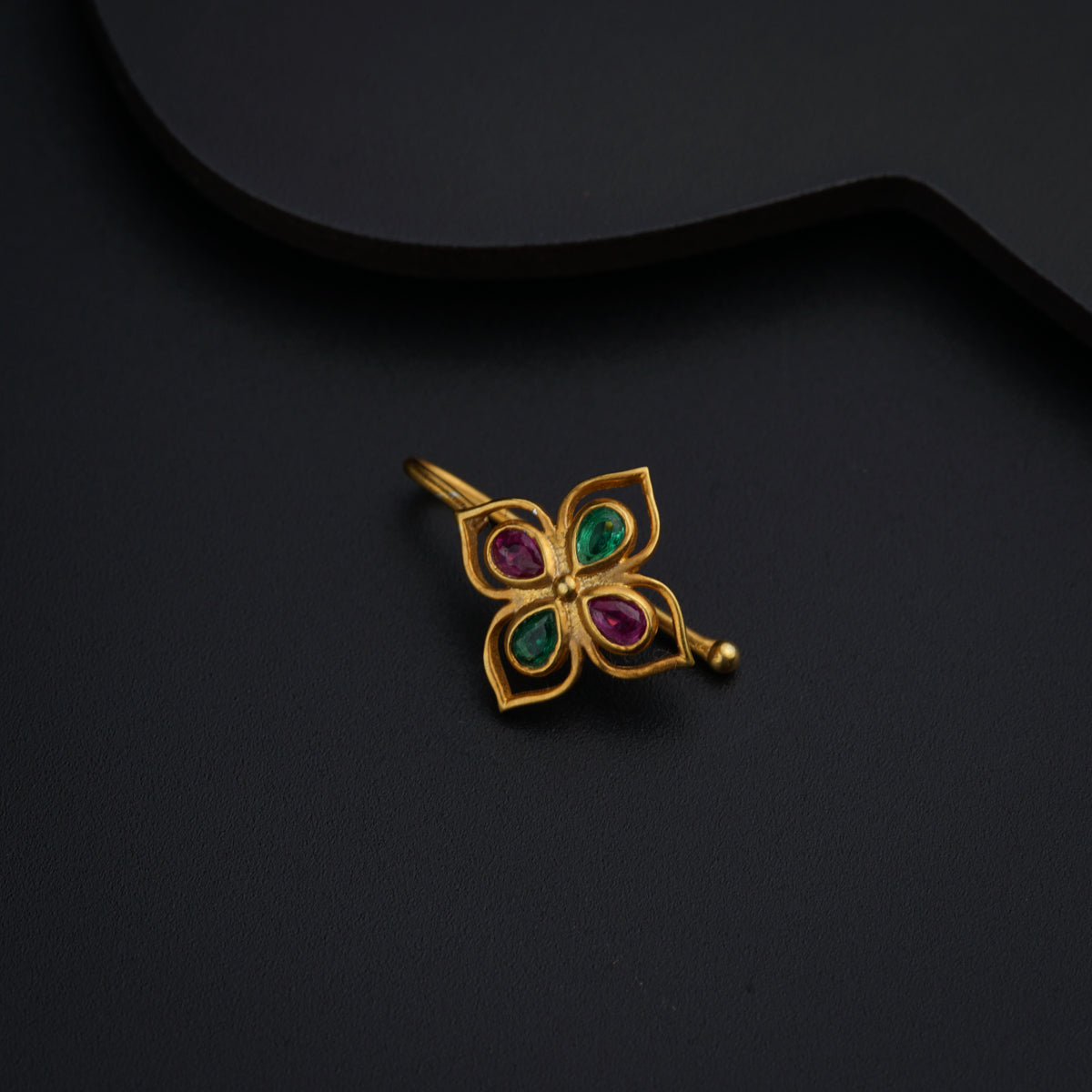 a close up of a brooch on a black surface