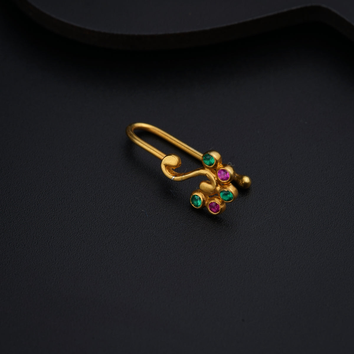 a close up of a pair of earrings on a black surface