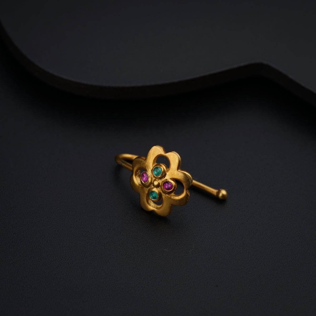 a close up of a gold ring on a black surface
