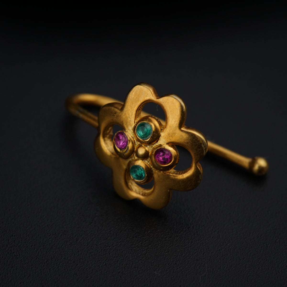 a close up of a gold ring on a black surface