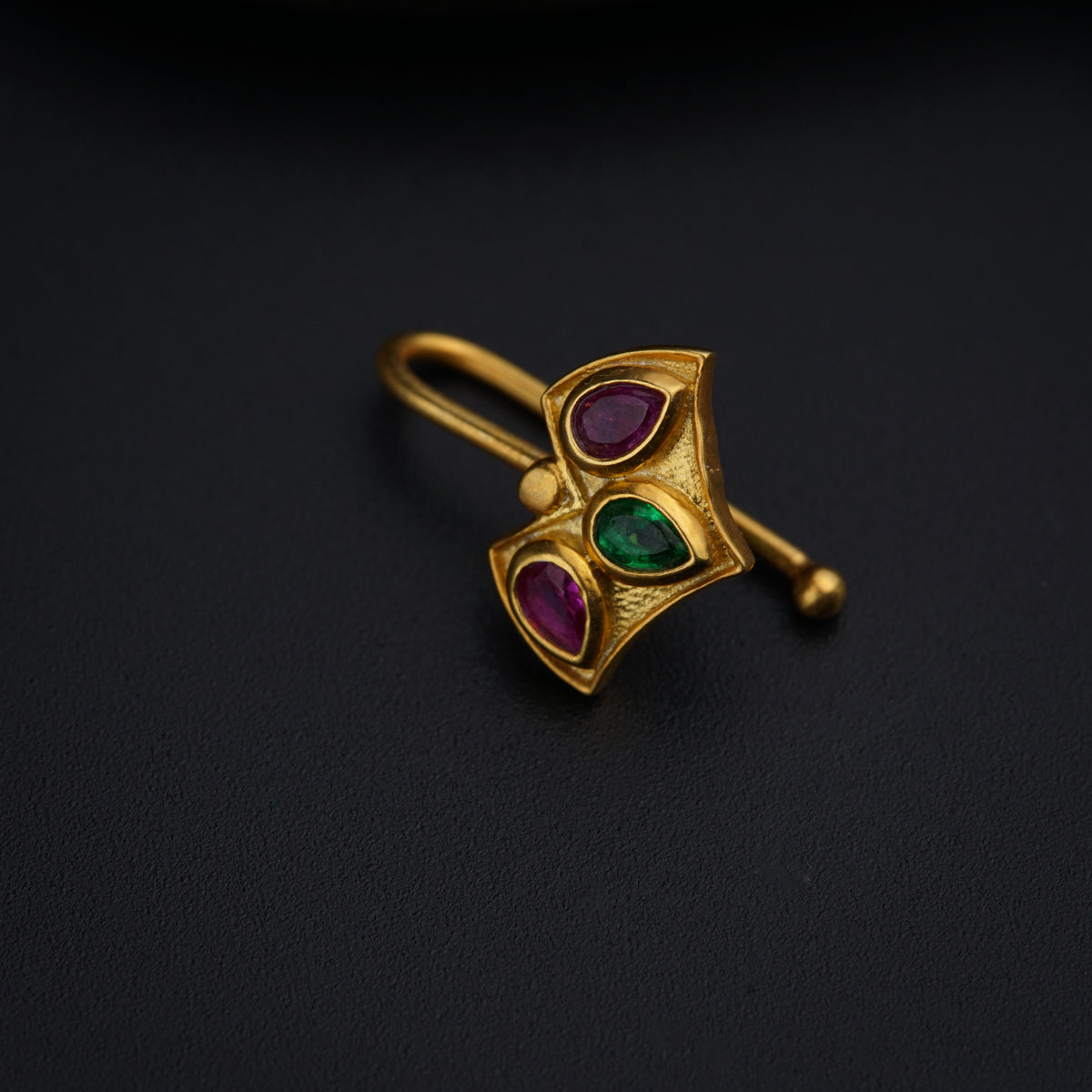 a close up of a brooch on a black surface