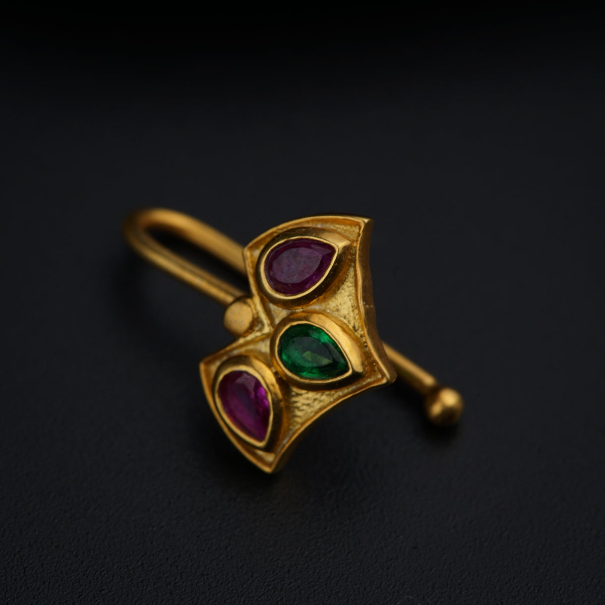 a close up of a brooch on a black surface