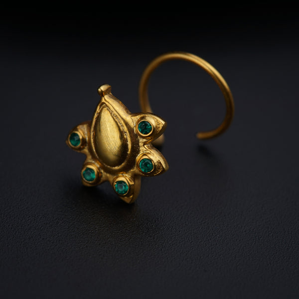 a close up of a gold ring with green stones