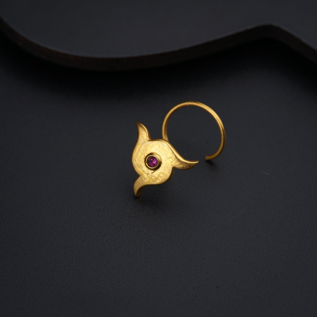 a gold ring with a pink stone in the middle