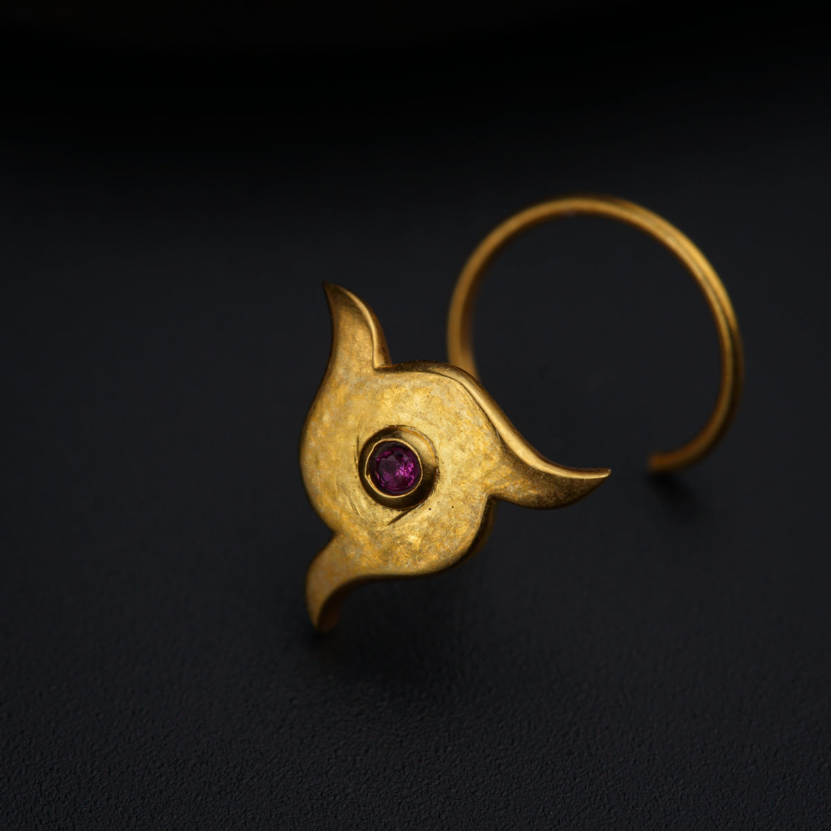 a close up of a gold ring with a purple stone