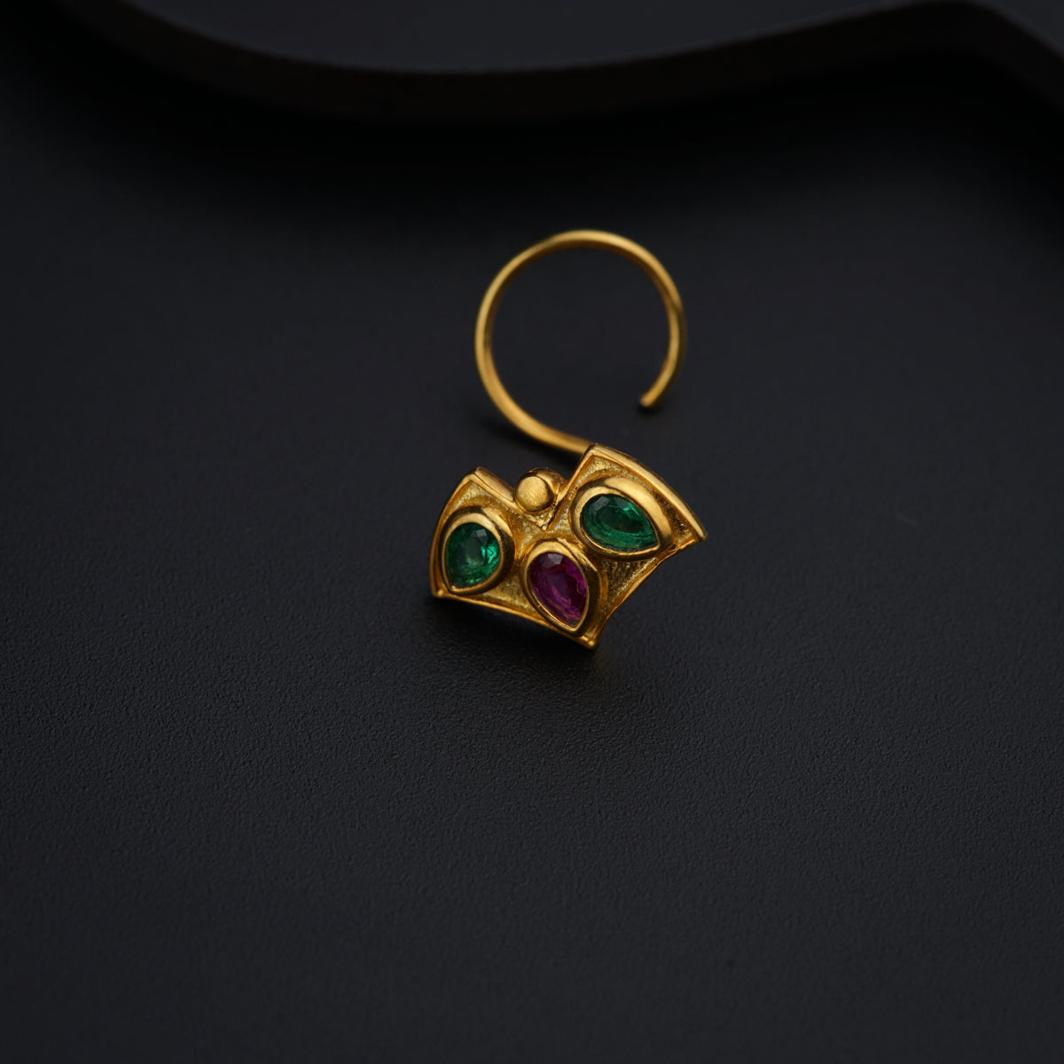 a close up of a pair of earrings on a black surface