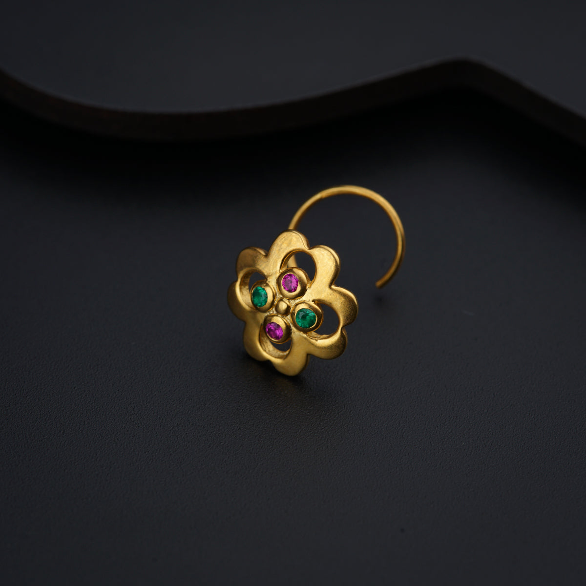 a close up of a pair of earrings on a black surface