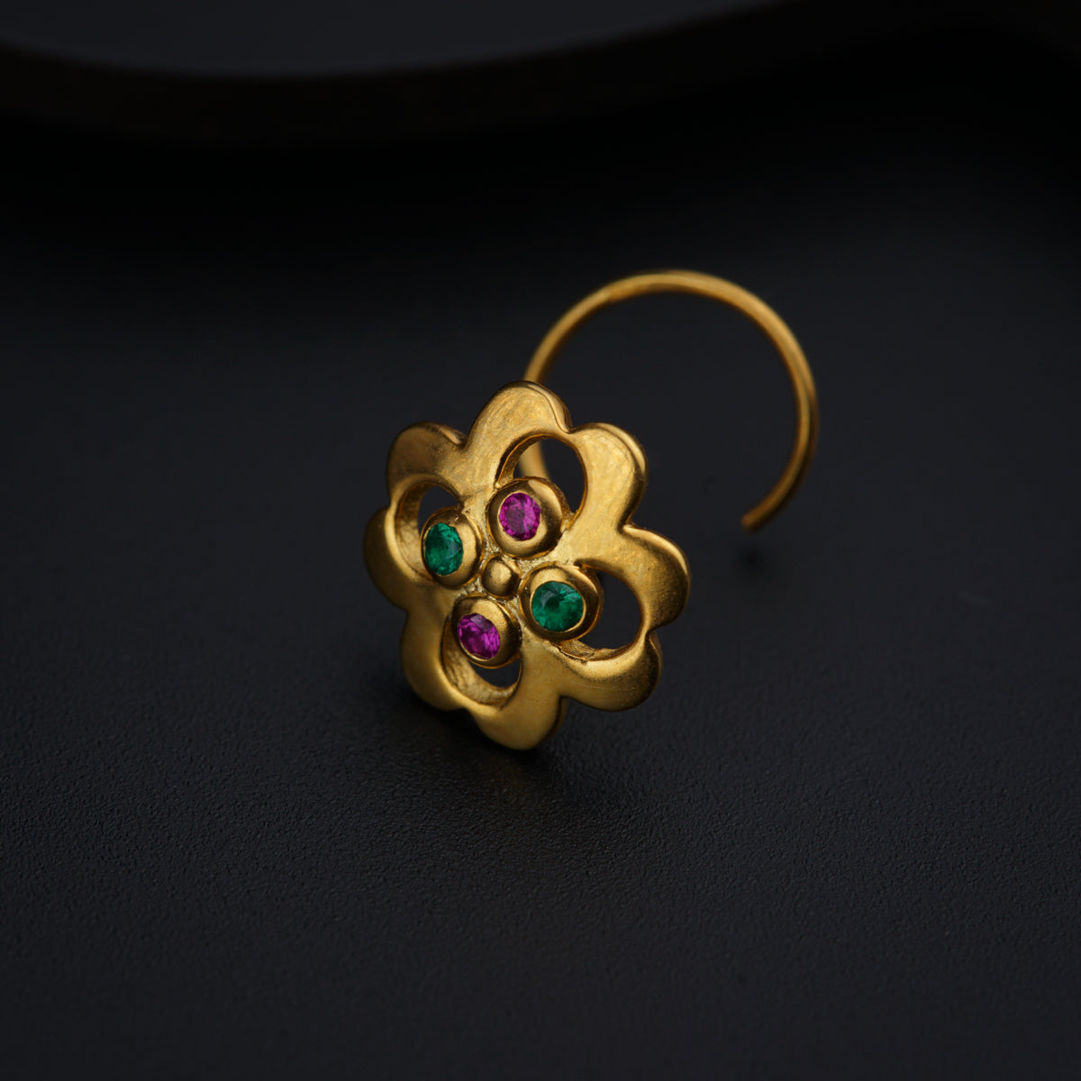 a close up of a pair of earrings on a black surface