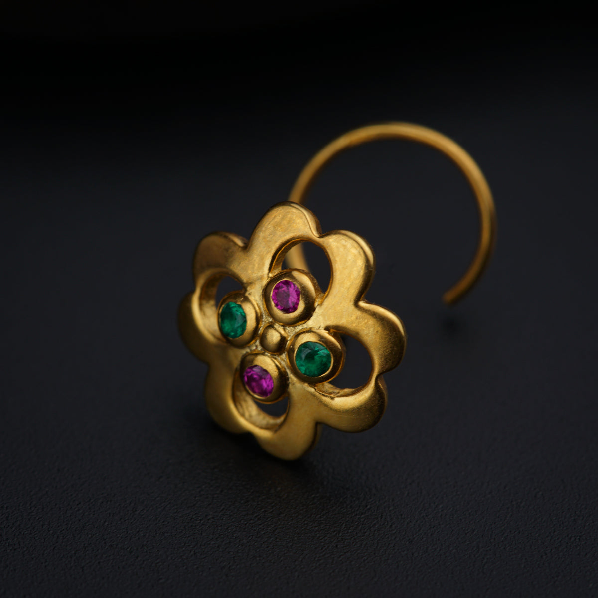a close up of a pair of earrings on a black surface