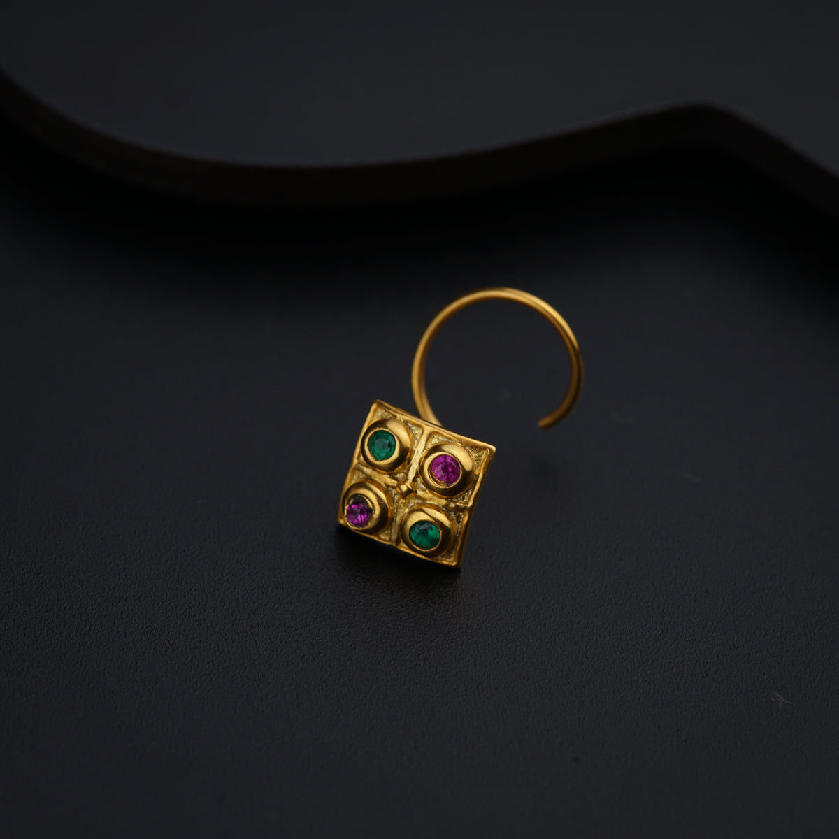a close up of a pair of earrings on a black surface
