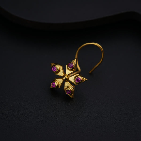 a close up of a pair of earrings on a black surface